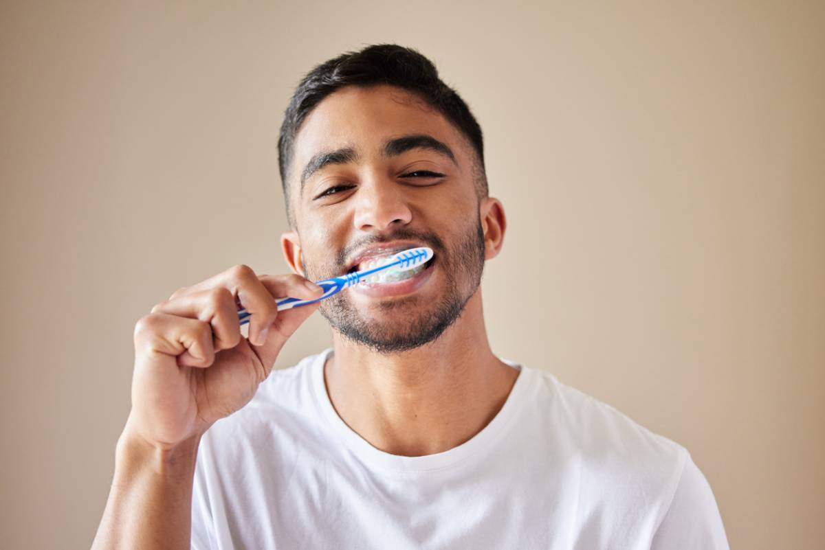 concept of man knowing how to take care of dental fillings brushing his teeth